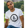 Man wearing a white t-shirt with a black Chi symbol and mudra symbol sitting on a big rock outdoors in a park.
